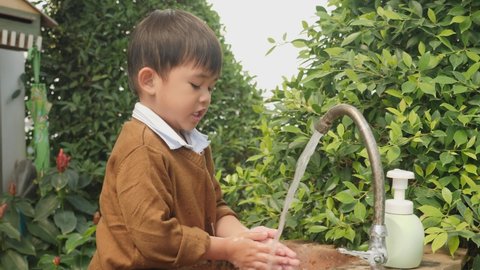 Cute little boy washing hands with soap prevent the spread of germs and bacteria and avoid infections corona virus.