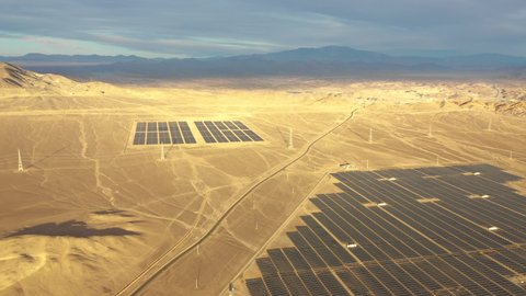 Aerial footage. Solar Energy Farm at Atacama Desert, Chile. Thousands solar modules rows passed along the Solar Energy PV Plant an amazing scene from an aerial drone point of view in a wild scenery
