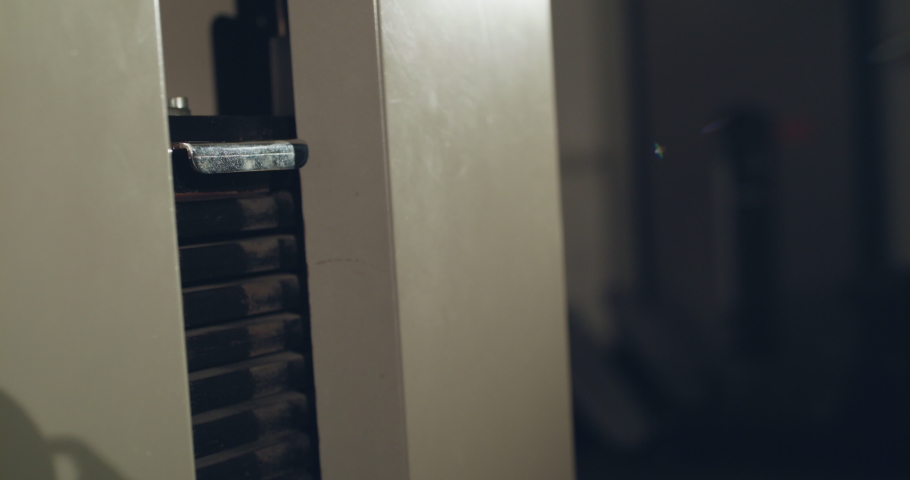 Female hand changes the weight with lever on the exercise machine. Slowly in 4K