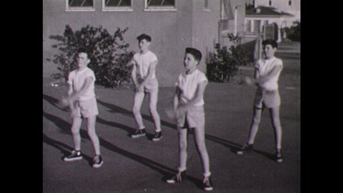 1950s: Young men perform exercises in unison.