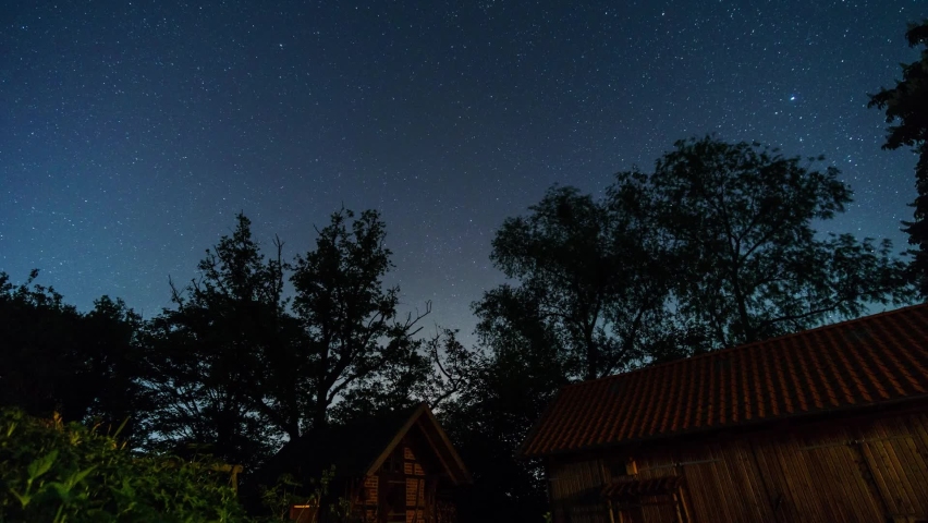 motion of stars as circular trails in northern direction to polaris over farm buildings