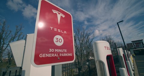 Staten Island, New York  United States - January 17,  2021: Tesla electric car Supercharger power station in strip mall parking lot. Sign indicating "Tesla 30 Minute General Parking"