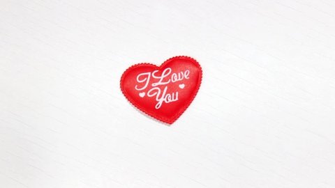 Decorative Red heart on a wooden white background and the inscription I love you. Symbol of Valentine's Day. Copy space. Top view.