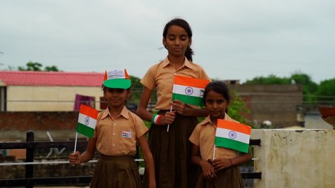 Jaipur, Rajasthan, India - Jan 2021: School children holding Indian flag walking at home wearing school uniform. Government school children with Indian flag