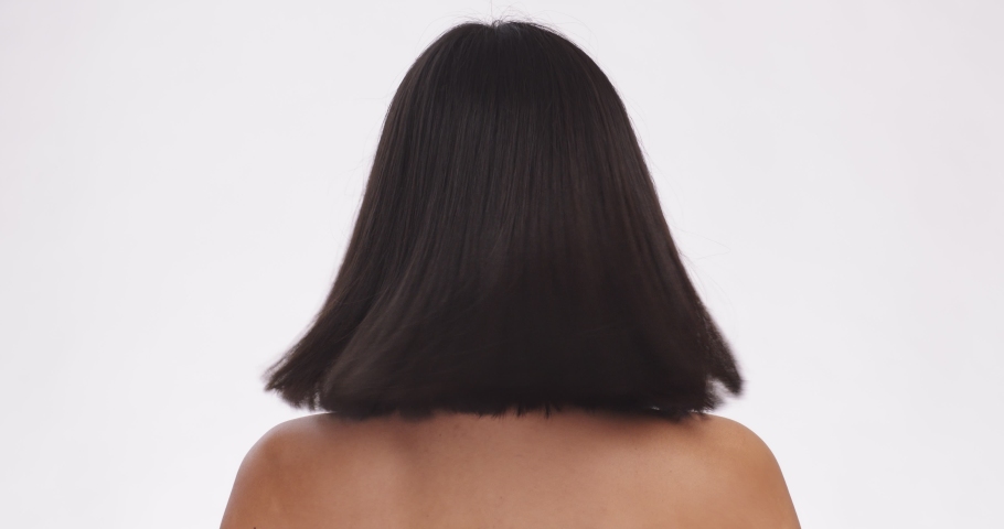 Perfect hair care. Back view of young lady playing with her hair, great cosmetics for hairstyling, white studio background, slow motion | Shutterstock HD Video #1065796603
