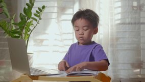 Asian child boy using a laptop and study online lesson at home. homeschooling distant learning, social distance during COVID-19 quarantine, not goto school, Homeschool remote education concept