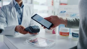 Pharmacy Drugstore Checkout Cashier Counter: Pharmacist and a Customer Using NFC Smartphone with Contactless Payment Terminal to Buy Prescription Medicine, Health Care Goods. Hand Focus Closeup - Powered by Shutterstock - Get 15% off with code: PIKWIZARD15