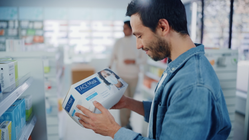 Pharmacy Drugstore: Portrait of Handsome Young Latin Man Searching to Purchase Best Face Mask Package, Chooses Box and Proceeds to Cashier Checkout Counter. Shelves full of Health Care Products | Shutterstock HD Video #1065814354