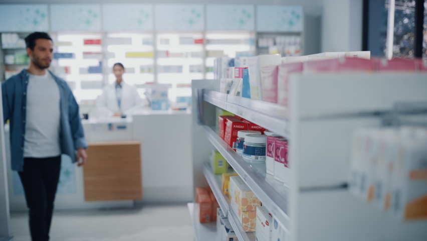 Pharmacy Drugstore: Portrait of Handsome Latin Man Choosing to Buy Medicine Browsing through the Shelf, Successfully finds what he Needs, Smiles Happily. Modern Pharma Store Health Care Products Royalty-Free Stock Footage #1065814471