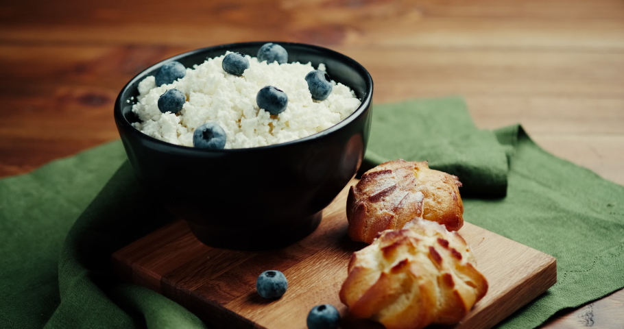 Cottage Cheese In Bowl. Homemade Curd Cheese Served With currant berries or blueberry. Healthy breakfast concept. Slide shot.