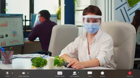 Businesswoman with visor and mask talking in front of camera having video call with partners. Pov of manager speaking with remotely team during online conference, footage with software overlay concept - Powered by Shutterstock - Get 15% off with code: PIKWIZARD15