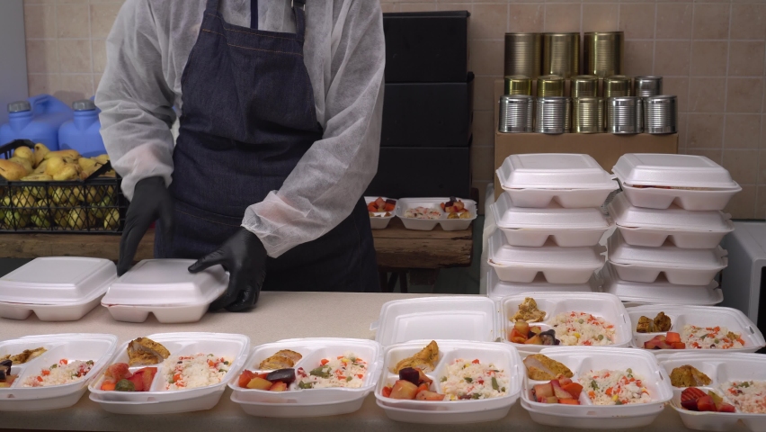 Food crisis. Online order. Meal Prep Containers from the restaurant. Chef packs hot food into lunch boxes. Disposable plastic tableware and packaging Royalty-Free Stock Footage #1065821533