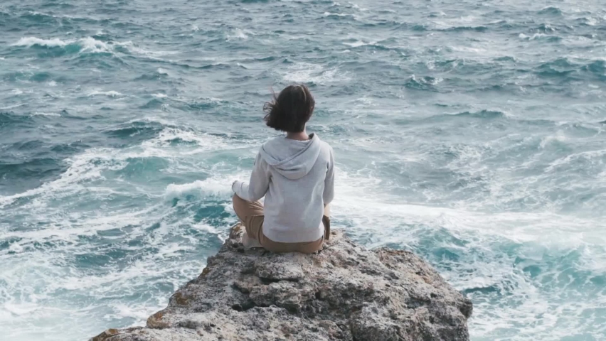 Young beautiful woman enjoy the sound of the waves. Get in touch with spiritual side Relax body and mind in nature outdoors. Slow Motion 240 FPS.