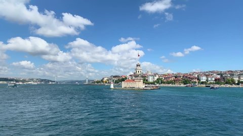 Footage of historical, famous landmark called "Maiden Tower" and Uskudar area of Asian side by Bosphorus in Istanbul. It is a sunny summer day. Camera moves forward.