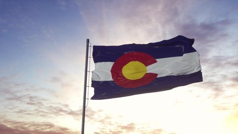State flag of Colorado waving in the wind. Dramatic sky background. 
