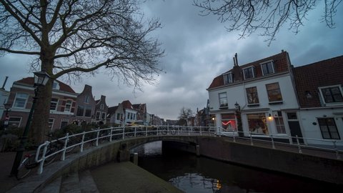Timelapse of sunset at a Canal with bridge and historic houses in the old city center of Haarlem, the Netherlands