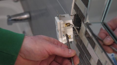 Man touching a broken electrical outlet with a screwdriver and getting himself electrocuted instantly.