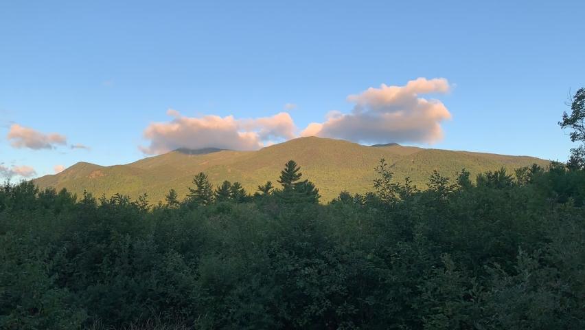 Sunrise and clouds over Whiteface Mountain in Wilmington New York, Time-lapse of Lake Placid sunrise, beautiful mountain scenery in Adirondack Mountains, serene and peaceful, ADK High Peaks