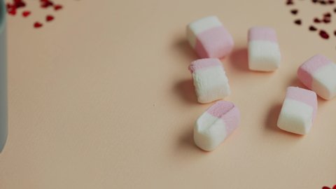 Valentine's day concept, womens impose marshmallows in a glass with coffee on a pink background and hearts. The 14th of February. St. Valentine's Day