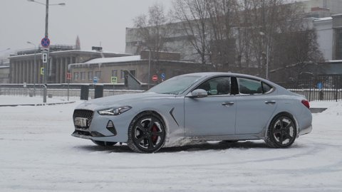 Moscow, Russia - CIRCA 2020: New car model Genesis G70 gray-blue on the road. Camera spin around car.