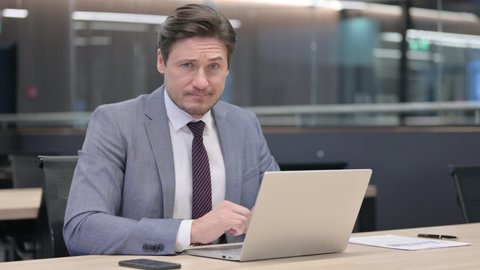 Middle Aged Businessman with Laptop Shaking Head, No 