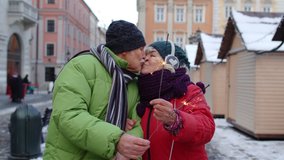 Senior couple with burning sparklers celebrating anniversary on winter city center street. Elderly family holding bengal lights enjoying Christmas eve. Active retired pensioners celebrating birthday - Powered by Shutterstock - Get 15% off with code: PIKWIZARD15