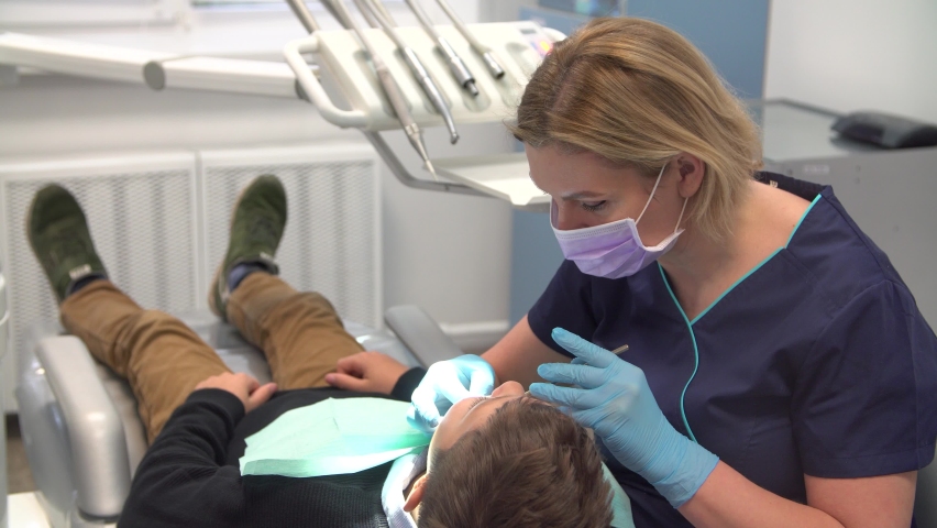 Dentist at work examines teenage boy | Shutterstock HD Video #1065883219