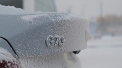 Moscow, Russia - CIRCA 2020: New car model Genesis G70 gray-blue on winter road. Trunk with sign G70