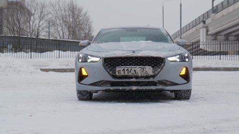 Moscow, Russia - CIRCA 2020: New car model Genesis G70 gray-blue on the road. Slow forward camera move in