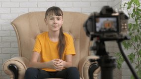 Young blogger makes video. A young teen record video for internet on camerain the room.
