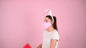Girl holding a gift with ears in a mask. High quality video.