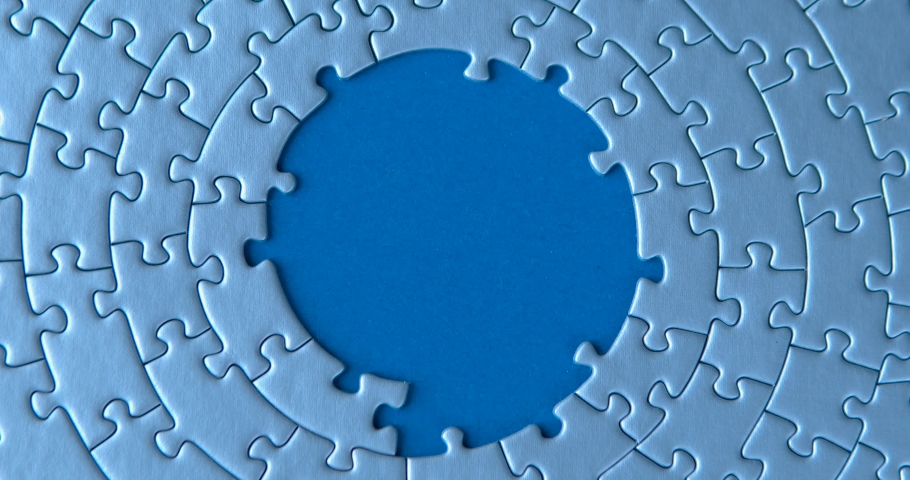 Female hand is putting down gray circular puzzles, pieces, stacking, matching together on blue background. Finishing, completion of work task. Successful achievement of goal. Decision, solution found. Royalty-Free Stock Footage #1065890893
