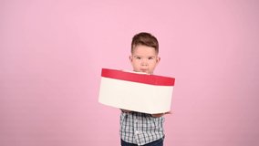 Child holding a gift box, heart-shaped. High quality video.