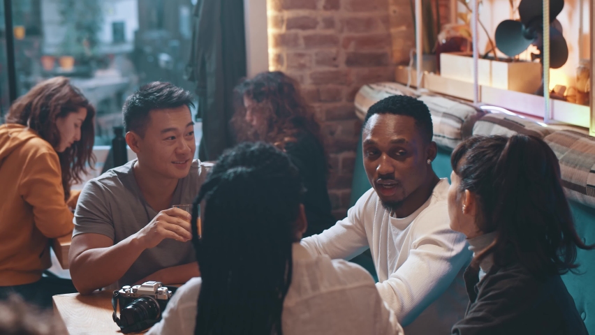 Lovely company of carefree multi-ethnic nice people sharing common table having warm conversation on coffee break. Meeting. Friendship. | Shutterstock HD Video #1065893602
