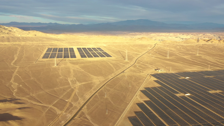 Aerial footage. Solar Energy Farm at Atacama Desert, Chile. Thousands solar modules rows passed along the Solar Energy PV Plant an amazing scene from an aerial drone point of view in a wild scenery
 | Shutterstock HD Video #1065893878