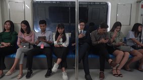 group of happy asian people passenger using smartphone  and digital tablet sitting in subway . social media addiction concept. crowd with Communication device in Public Transport in city lifestyle .
