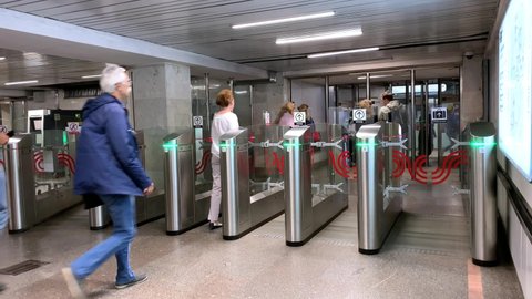Moscow, Russia - August 12 2019: Passengers pass through automatic turnstiles at the Moscow metro station. People are exiting public subway station Sviblovo wearing pants and shirts. 