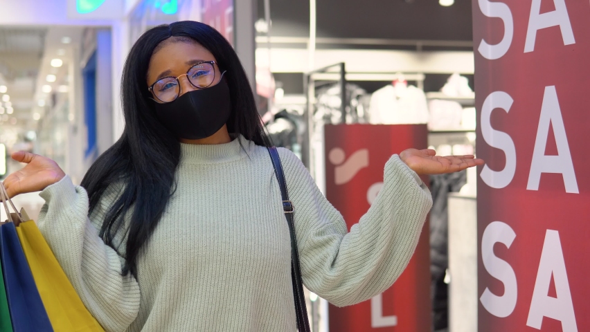 Smiling african american girl while shopping in the supermarket. Big sale