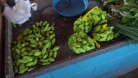 Close up of fresh green peppers on blue market counter inside market in the Amazon. Concept of food, gastronomy, business, sale, spices, healthy food, trade.