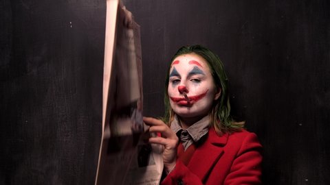 New York, USA - 12 October 2019: Joker Cosplay Actor Smoking and burn the New York Times Newspaper, Halloween Concept