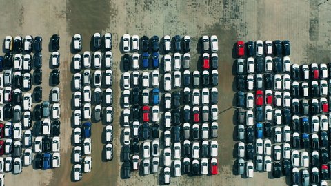 Aerial shot of new cars at a car dealer parking lot.