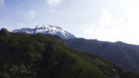 4K aerial footage of a highest African continent summit - Kilimanjaro Uhuru Peak 5895m volcano covered with snows. Drone point of view flying up at cca 3600m. Umbwe route, Tanzanian National Park.