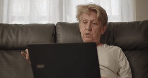 Older women have to work from home with online training meetings and she was in a comfortable position leaning on the sofa at her home alone.