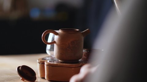 a man pours boiling water into a clay teapot for a tea ceremony. Chinese tea ceremony