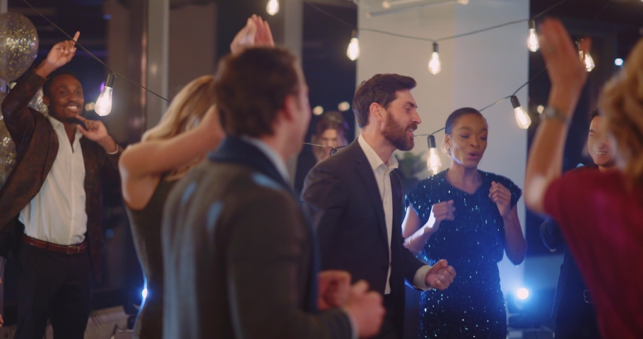 Excited multi-ethnic company team of happy coworkers men and women dancing together applauding enjoying to celebrate corporate party together. Royalty-Free Stock Footage #1065924997
