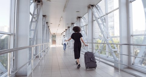Afro american man in medical mask meets his wife girl with luggage suitcase at airport terminal couple hugs boyfriend rejoices at arrival of traveler girlfriend quarantine concept flight cancellation