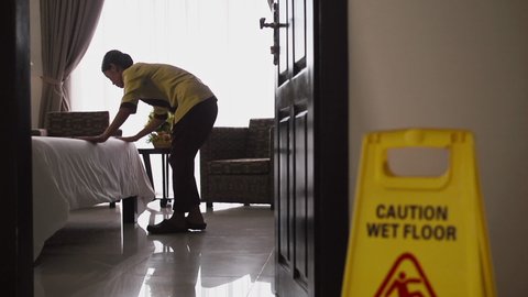 Asian maid working and cleaning in luxury hotel room. Young people at work in tourist resort. Busy woman as staff member or housemaid or cleaner. Dolly shot