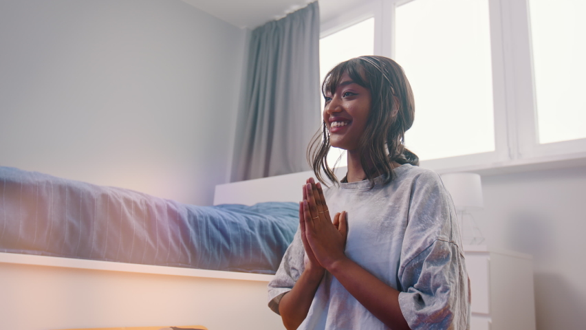 Beautiful young african american black woman meditating in her bedroom. first meditation attempt with smile on her face. High quality 4k footage | Shutterstock HD Video #1065936469