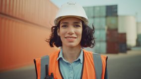 Smiling Portrait of a Beautiful Hispanic Female Industrial Engineer in White Hard Hat, Safety Vest and with Two-Way Radio Working in Logistics Center. Inspector or Supervisor in Container Terminal. - Powered by Shutterstock - Get 15% off with code: PIKWIZARD15