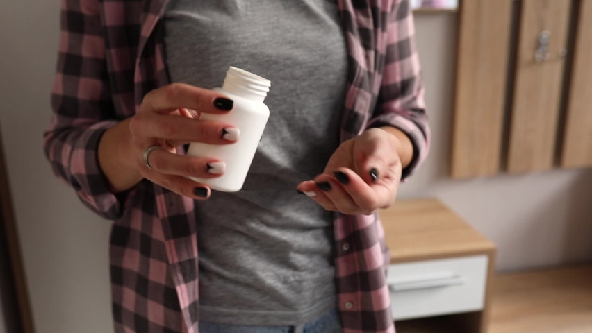 Woman poured pills vitamins or drugs tablets from the bottle onto the palm, Medicine and health care concept at home.
 Royalty-Free Stock Footage #1065943981